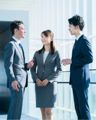 向かい合い語り合う三人の男女の会社員